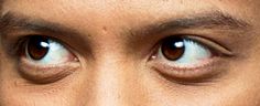 a close up of a man's eyes with brown hair and blue eyeshades