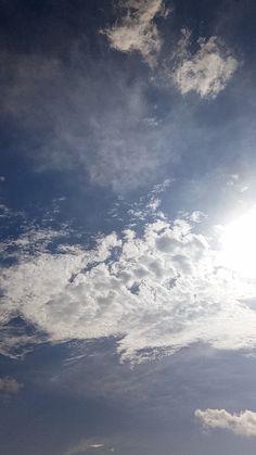 an airplane flying in the sky with some clouds