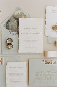 the wedding stationery is laid out on top of each other, including rings and envelopes