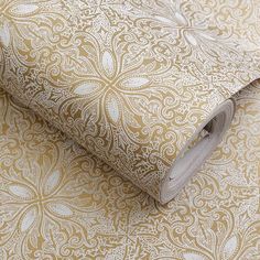 a close up view of a wallpaper with gold and white designs on it's surface