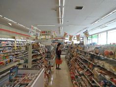 a woman standing in the aisle of a grocery store