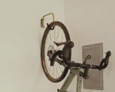 a bike mounted to the side of a wall with a bicycle on it's back