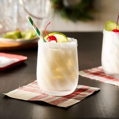 two glasses filled with drinks sitting on top of a table