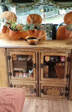 the inside of a van with pots and baskets on it's windowsills