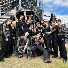 a group of young men standing next to each other in front of a metal structure