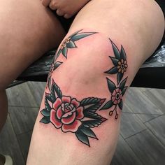 a woman's thigh with a rose tattoo on her left leg and the rest of her leg behind her