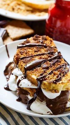 a piece of cake on a plate with ice cream and chocolate drizzles