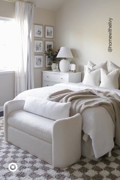 a white bed sitting in a bedroom next to a window