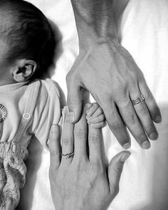 two people holding hands while laying in bed