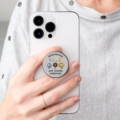 a person holding up a cell phone with an app on the front and back buttons