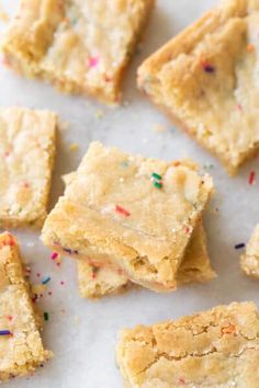 several pieces of cake mix cookie bars with sprinkles on white parchment paper