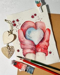 a watercolor painting of two hands holding a heart on top of a piece of paper