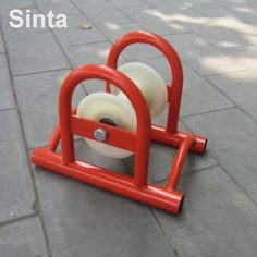 a red and white object sitting on top of a sidewalk