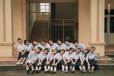 a group of young women sitting next to each other in front of a building on steps