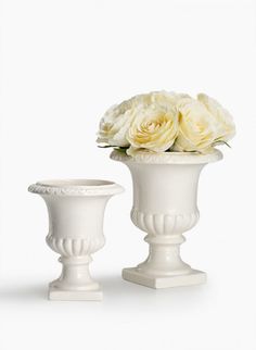 two white vases with flowers in them