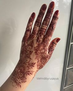 a woman's hand with henna tattoos on it