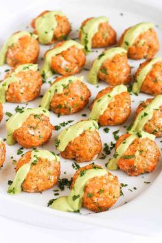 small appetizers are arranged on a white platter and garnished with avocado