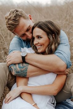 a man and woman hugging each other in a field