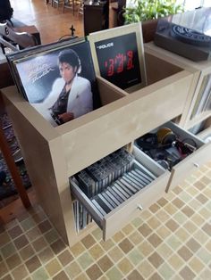 an entertainment center with dvd's and cds in the drawers on top of it