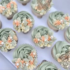 cupcakes decorated with flowers and butterflies are on display for guests to enjoy in