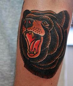 a black and red bear tattoo on the left arm with an open mouth in front of it