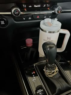 the interior of a car with an automatic coffee cup holder in the center console area