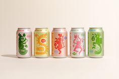 four cans of various types of soda on a white background, each with different designs and colors