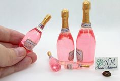 there are three miniature pink bottles with gold caps