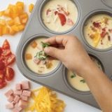 a muffin tin filled with different types of food