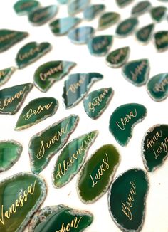 some green and gold leaf shaped magnets with names on them