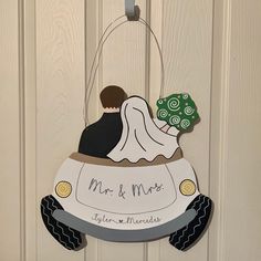 a door hanger with a bride and groom in a wedding car on it's side