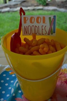 a yellow bucket filled with peanuts and a sign that says pool noodles next to it