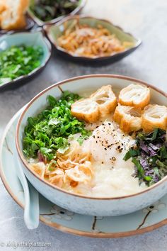 a bowl filled with rice and vegetables on top of a table next to other dishes