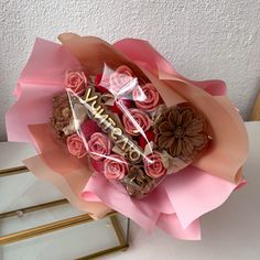 a bouquet of flowers with the word love written on it and chocolates in the middle