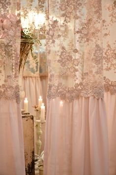 the curtains in this room are decorated with flowers and laces, along with candles