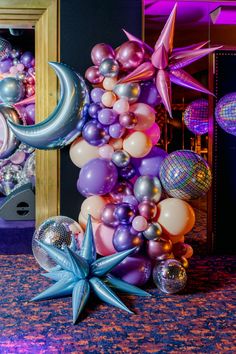 balloons and stars are arranged on the floor in front of a mirror at a party