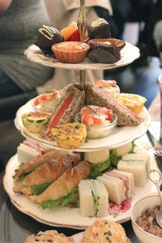 three tiered trays filled with different types of food and pastries on top of each other