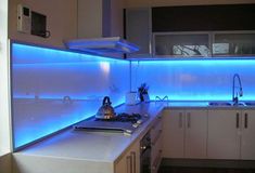 a kitchen with blue lights on the wall