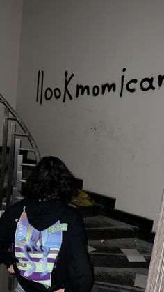 a woman walking up the stairs in front of a sign