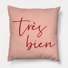 a pink pillow with the words tress bien printed in red ink on it