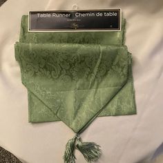 the table runner is green and has a tassel on it