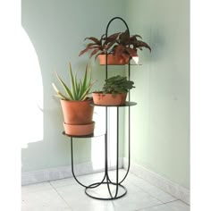 three potted plants sitting on top of a metal stand