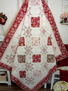 a red and white quilt hanging on a wall