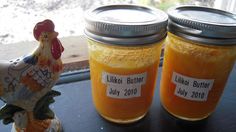 two mason jars with labels on them sitting next to a chicken figurine and window sill