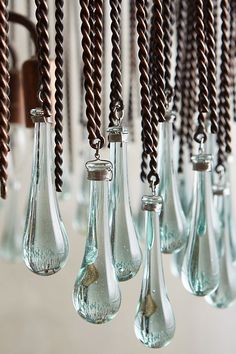 several glass vases are hanging from the ceiling