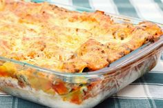 a casserole dish with meat and cheese in it sitting on a tablecloth