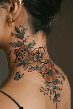 a woman's neck is adorned with flowers and leaves on the back of her neck