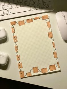 a computer keyboard sitting next to a mouse on top of a white desk with a piece of paper