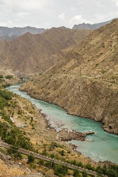 a river running through a valley surrounded by mountains