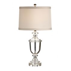 a table lamp with a white shade on the top and silver trimming around it